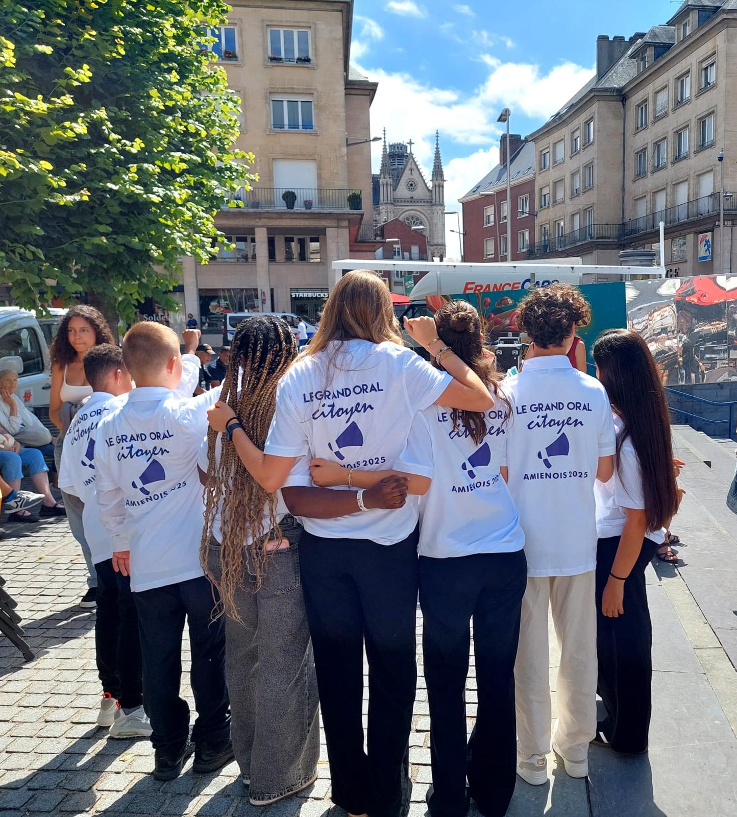 Photo de groupe de dos avec les pulls du Grand Oral Citoyen.